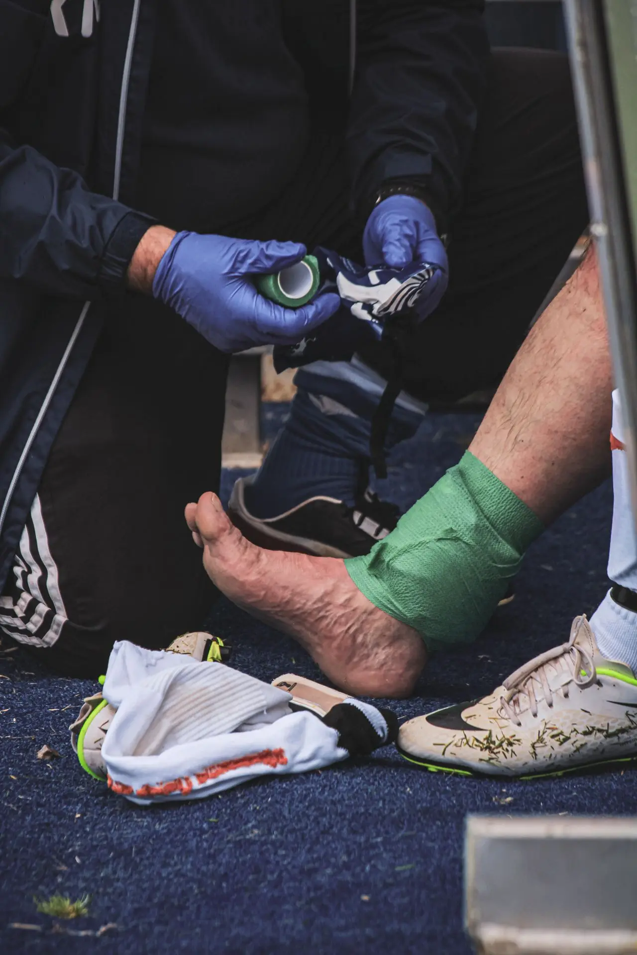 Ankel som tapes med sportstape ute på idrettsbanen